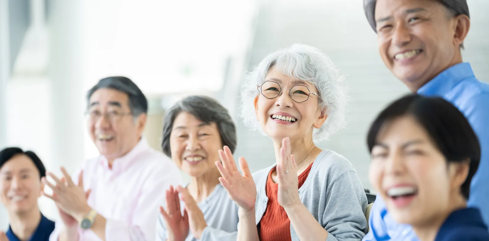 笑顔で拍手する高齢者とスタッフ